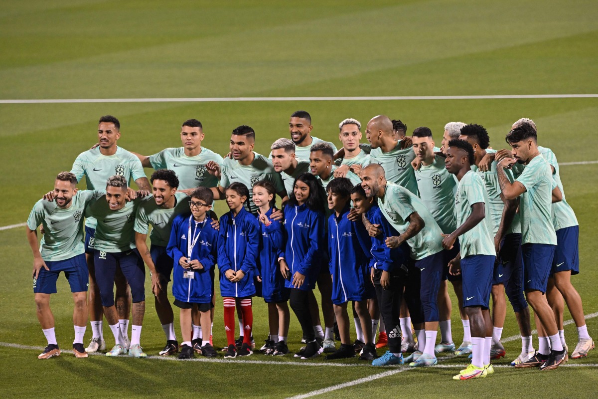 Brazil’s players pose for a photo with supporters ahead of a training session yesterday. 
