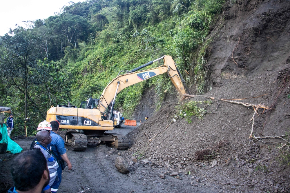 Rescue teams use heavy equipment to remove soil after a mountain landslide in the sector El Ruso, Pueblo Rico municipality, in northwestern Bogota, Colombia, on December 5, 2022. (Photo by STRINGER / AFP)