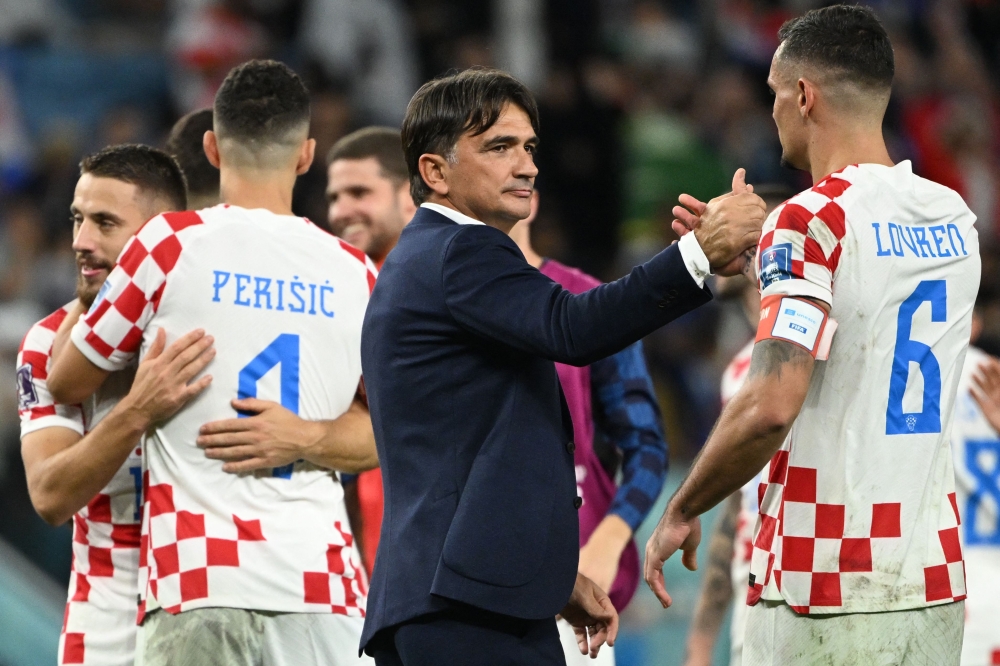 Croatia's coach #00 Zlatko Dalic (C) congratulates Croatia's defender #06 Dejan Lovren for their win in the Qatar 2022 World Cup round of 16 football match between Japan and Croatia at the Al-Janoub Stadium in Al-Wakrah, south of Doha on December 5, 2022. (Photo by Ina Fassbender / AFP)

