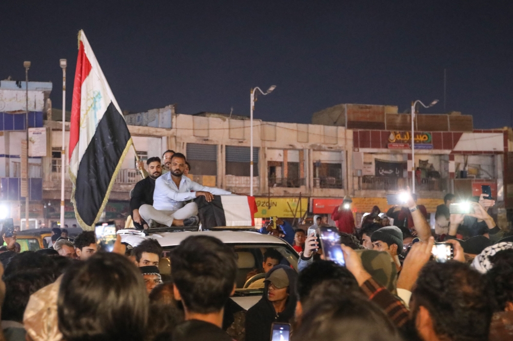 Mourners accompany the casket of one of the 2 protesters killed earlier in clashes with security forces, in the southern Iraqi city of Nasiriyah, the regional capital of Dhi Qar province, on December 7, 2022.  (Photo by Asaad NIAZI / AFP)