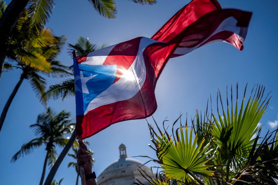 A person holds a Puerto Rican flag in front of the Capitol building during a protest of teachers demanding salary increase and better working conditions, in San Juan, Puerto Rico, on February 9, 2022. File Photo / Reuters