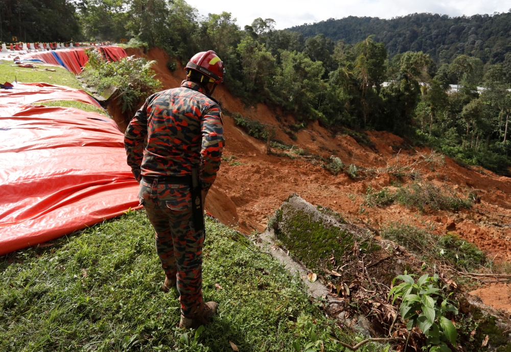 A rescue crew member checks the landslide area during a rescue and evacuation operation following a landslide at a campsite in Batang Kali, Selangor, Malaysia, December 17, 2022. REUTERS/Hasnoor Hussain
