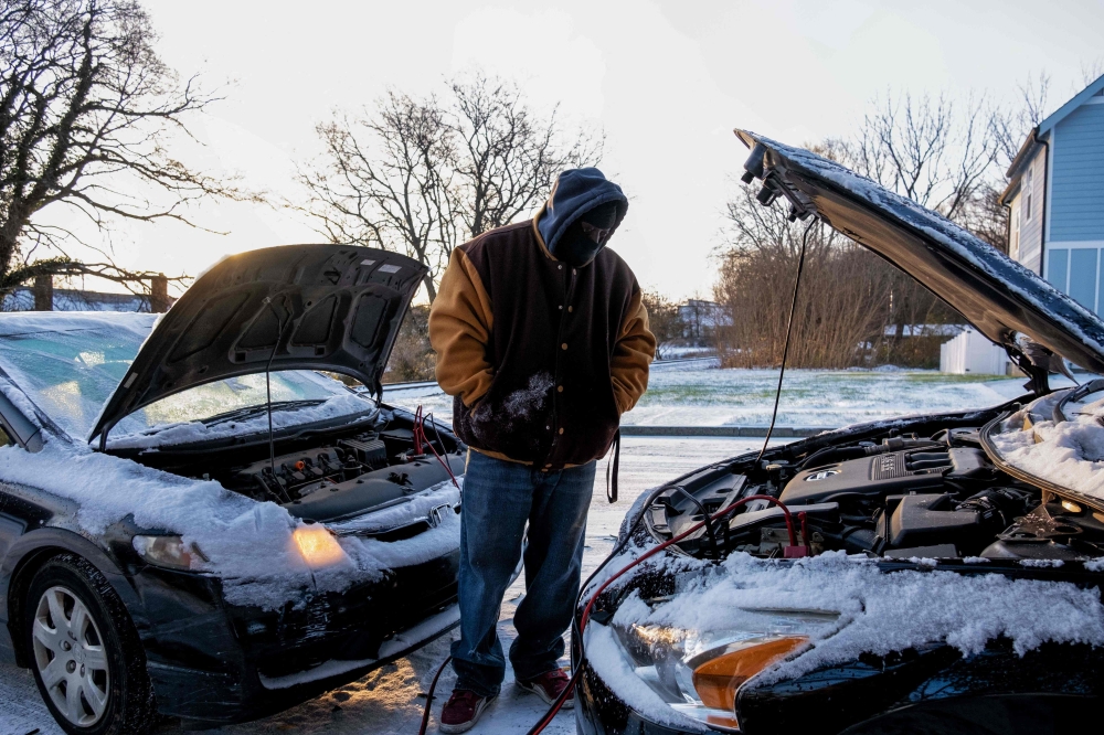 Antonio Smothers jumps his vehicle on December 23,2022 after winter storm Elliot moved through the Middle Tennessee region leaving behind freezing rain, snow and below freezing temperatures, in Nashville, Tennessee on December 23, 2022. (Photo by Seth Herald / AFP)