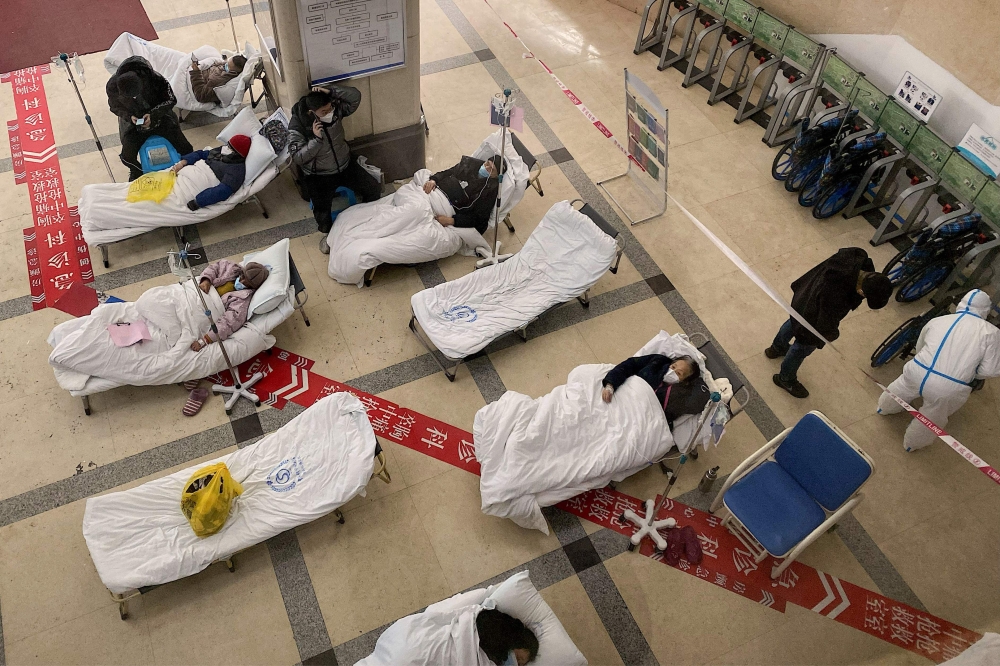 Covid-19 patients lie on hospital beds in the lobby of the Chongqing No. 5 People's Hospital in China's southwestern city of Chongqing on December 23, 2022. (Photo by Noel Celis / AFP)