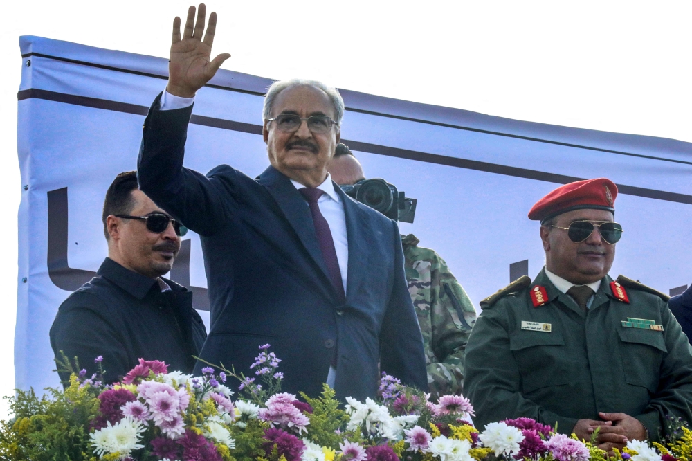 Libya's eastern military chief Khalifa Haftar (second left) gestures after a speech a rally marking the 71st anniversary of the country's independence from Italy in the eastern city of Benghazi on December 24, 2022. (Photo by Abdullah DOMA / AFP)