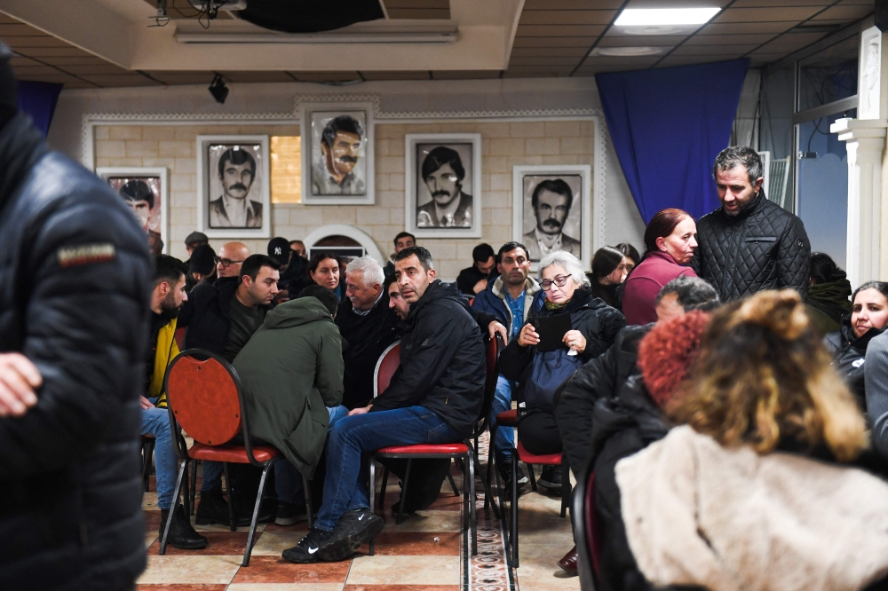 Participants gather to pay tribute to the victims of a shooting, inside the 