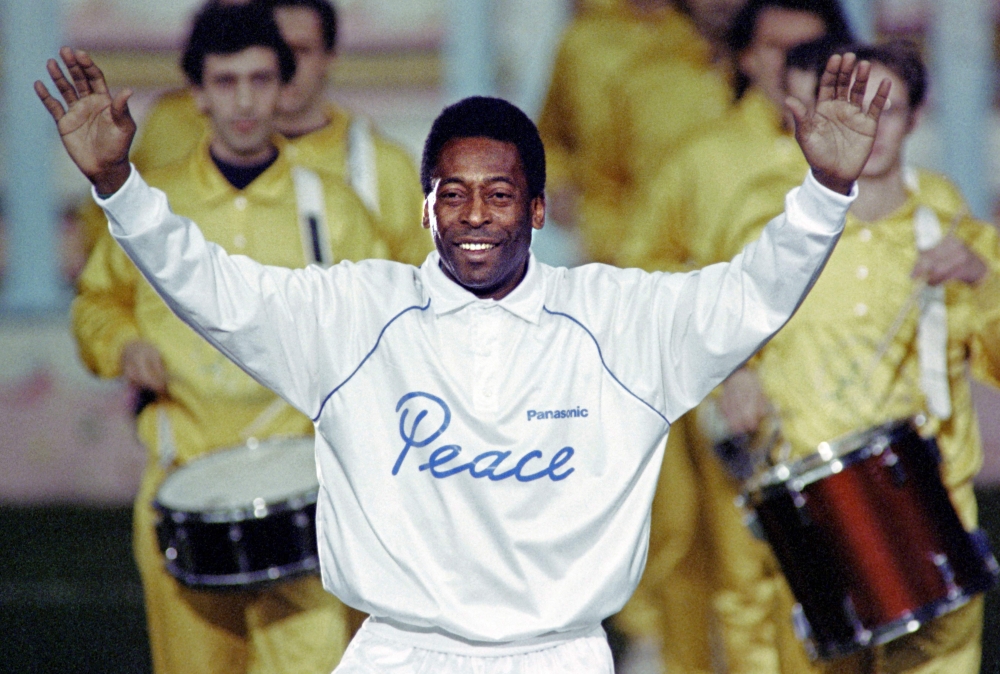 In this file photo taken on October 31, 1990 Pele opens his arms as he acknowledges cheers from a crowd of spectators during a ceremony in Milan to celebrate his fiftieth birthday. (Photo by Gerard MALIE / AFP)