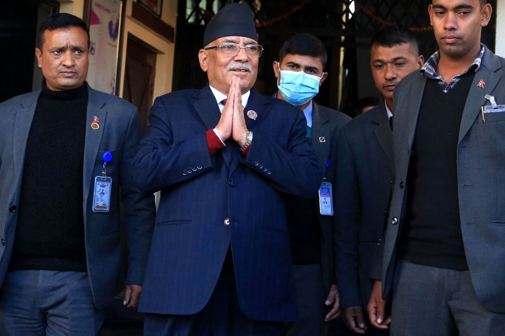 Nepal's former guerrilla leader Pushpa Kamal Dahal (second left), better known by his nom de guerre Prachanda gestures to media representatives as he leaves for the president's office to claim majority for his appointment as the new prime minister, in Bhaktapur on the outskirts of Kathmandu on December 25, 2022.  (Photo by Dipesh Shrestha / AFP)