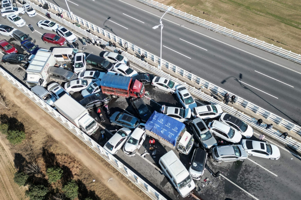 This aerial photo taken on December 28, 2022 shows a multi-vehicle collision on Zhengxin Yellow River Bridge in Zhengzhou, in China's central Henan province. (Photo by AFP) / China OUT
 