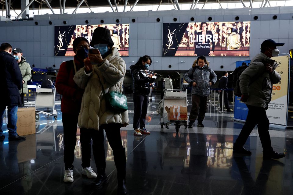 Travellers stand by their luggage at Beijing Capital International Airport, amid the coronavirus disease (COVID-19) outbreak in Beijing, China December 27, 2022. REUTERS/Tingshu Wang
