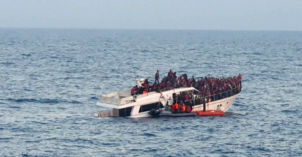A handout photo provided by the Lebanese Army on December 31, 2022, shows a sinking migrant boat in Mediterranean waters, off the country's northern coast near Tripoli during a rescue operation by the Lebanese navy. (Photo by Lebanese Army Website / AFP) 