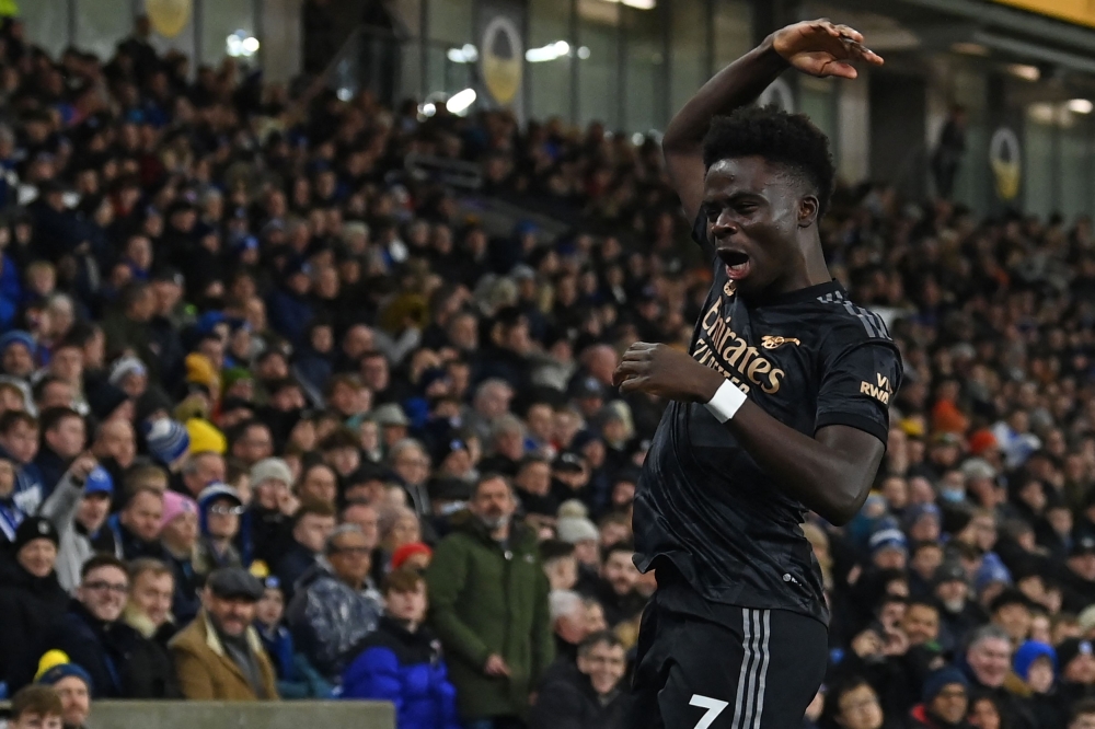 Arsenal's English midfielder Bukayo Saka celebrates after scoring the opening goal of the English Premier League match between Brighton and Hove Albion and Arsenal at the American Express Community Stadium in Brighton, southern England on December 31, 2022. (Photo by Glyn KIRK / AFP)