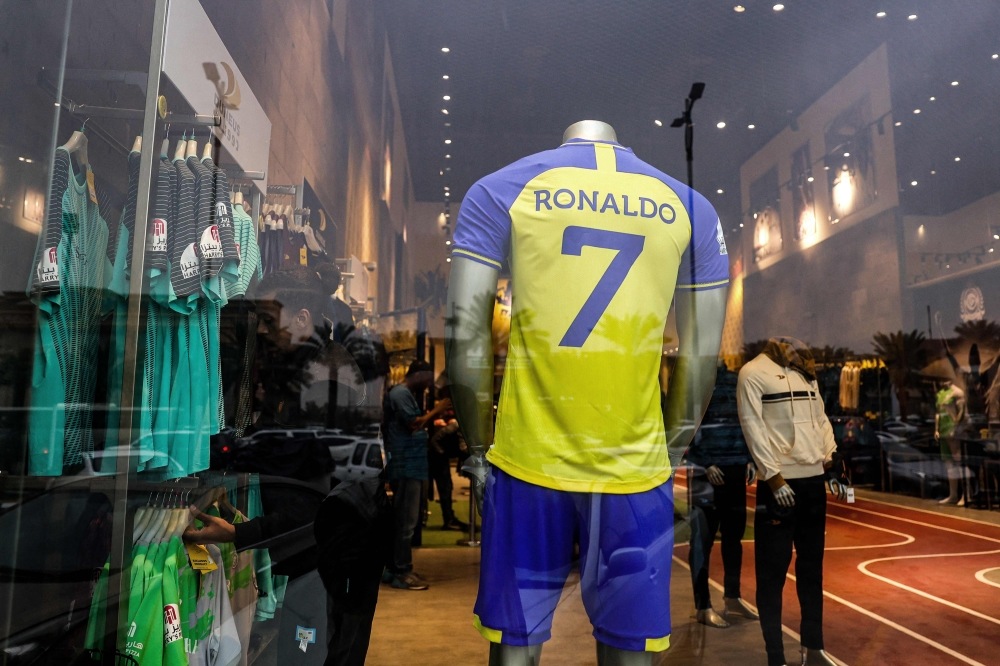 The full set football uniform for Saudi club al-Nasr's new Portuguese forward Cristiano Ronaldo (#7) is displayed at a sports shop carrying the club's paraphernalia in the capital Riyadh on January 2, 2023.  (Photo by Fayez Nureldine / AFP)