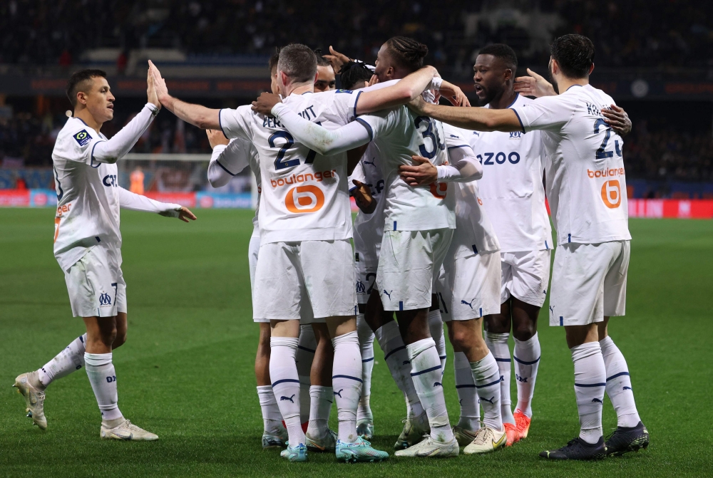 Marseille's Portuguese defender Nuno Tavares (centre) celebrates with teammates after scoring his team's first goal during the French L1 football match between Montpellier Herault SC and Olympique de Marseille (OM) at Stade de la Mosson in Montpellier, southern France, on January 2, 2023. (Photo by Pascal GUYOT / AFP)