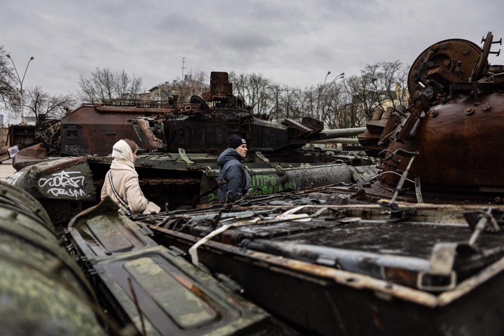 Pedestrians look at the destroyed Russian military vehicles at an open air exhibition of destroyed Russian equipment in Kyiv on January 5, 2023. (Photo by Sameer Al-Doumy / AFP)