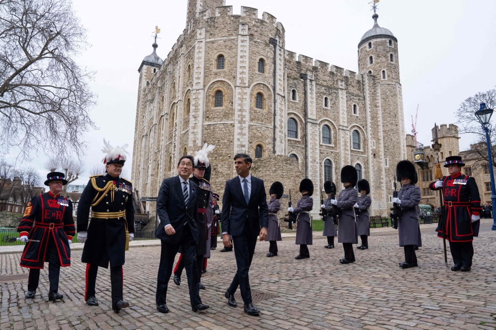Britain's Prime Minister Rishi Sunak (right) welcomes Japan's Prime Minister Fumio Kishida upon his arrival at the Tower of London, central London, on January 11, 2023 ahead of their meeting. (Photo by Carl Court / POOL / AFP)
