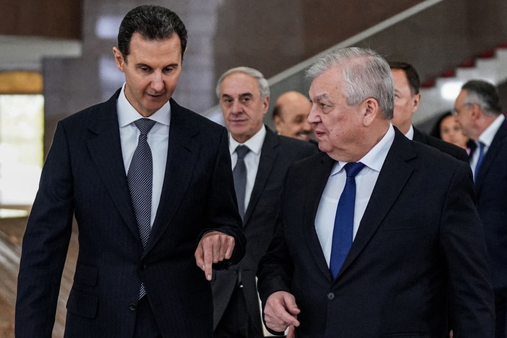 A handout picture released by the official Syrian Arab News Agency shows Syria's President Bashar al-Assad (left) receiving Russia's Special Envoy for Syria Alexander Lavrentiev and his accompanying delegation in the capital Damascus on January 12, 2023. (Photo by SANA / AFP)