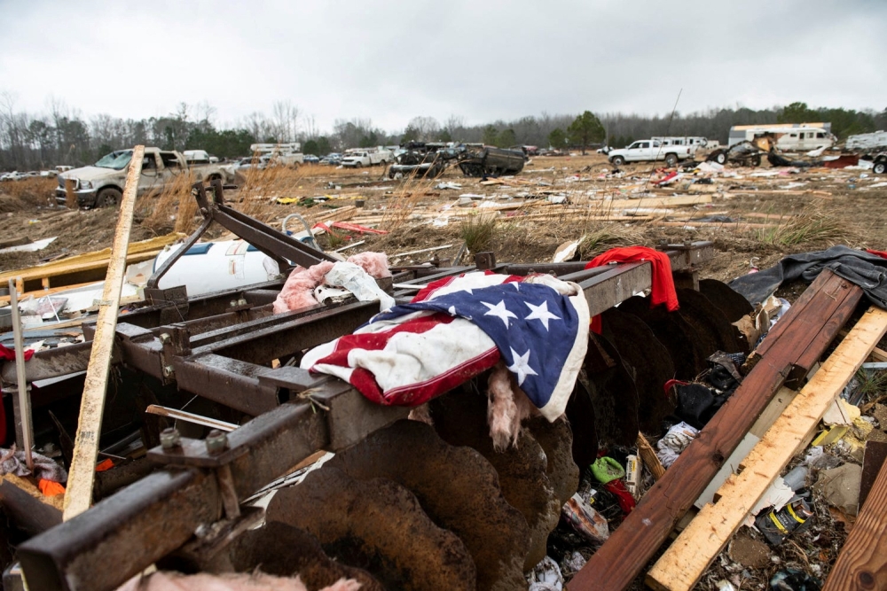 A flag is draped on the remnants of a home destroyed by a tornado on County Road 140 in Old Kingston, Alabama, US, January 13, 2023. (Jake Crandall/USA Today Network via REUTERS)