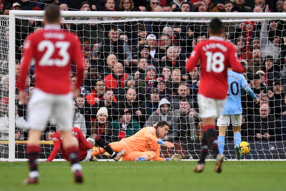 Manchester United's English striker Marcus Rashford (left) scores the team's second goal past Manchester City's Brazilian goalkeeper Ederson during the English Premier League football match between Manchester United and Manchester City at Old Trafford in Manchester, north west England, on January 14, 2023. (Photo by Oli SCARFF / AFP)