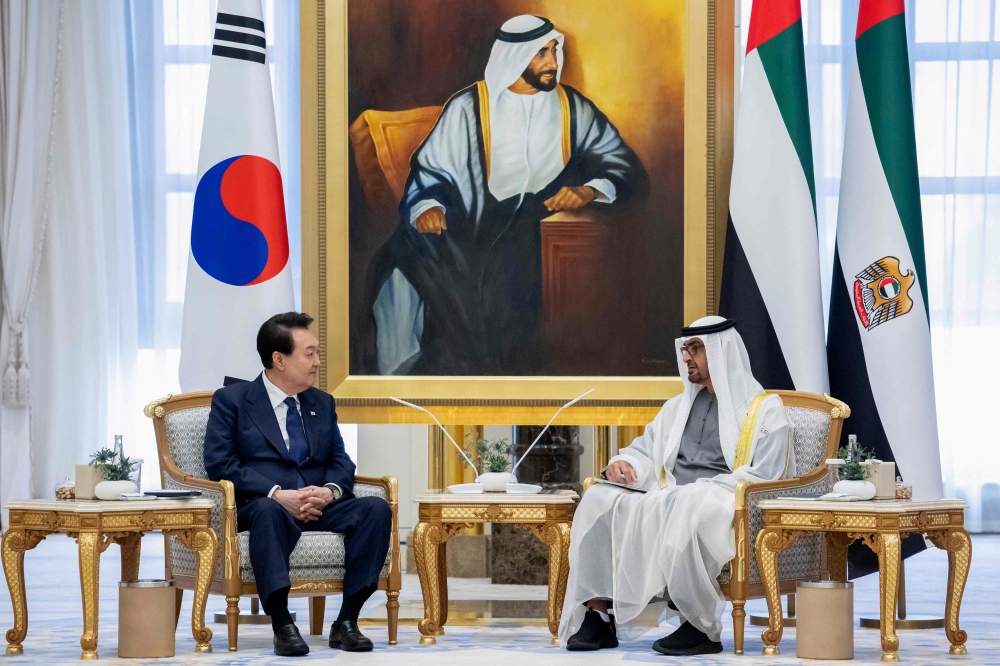 This handout image provided by the UAE Presidential court shows Emirati President Sheikh Mohamed bin Zayed Al-Nahyan (R) meeting with South Korea's President Yoon Suk-yeol during a state visit at the royal palace in Abu Dhabi, on January 15, 2023. (Photo by Rashed AL-MANSOORI / UAE PRESIDENTIAL COURT / AFP)