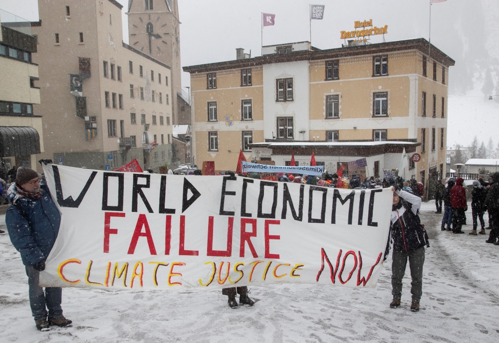 Climate activists display a banner during a protest ahead of the World Economic Forum (WEF) 2023 in the Alpine resort of Davos, Switzerland, January 15, 2023. (REUTERS/Arnd Wiegmann)