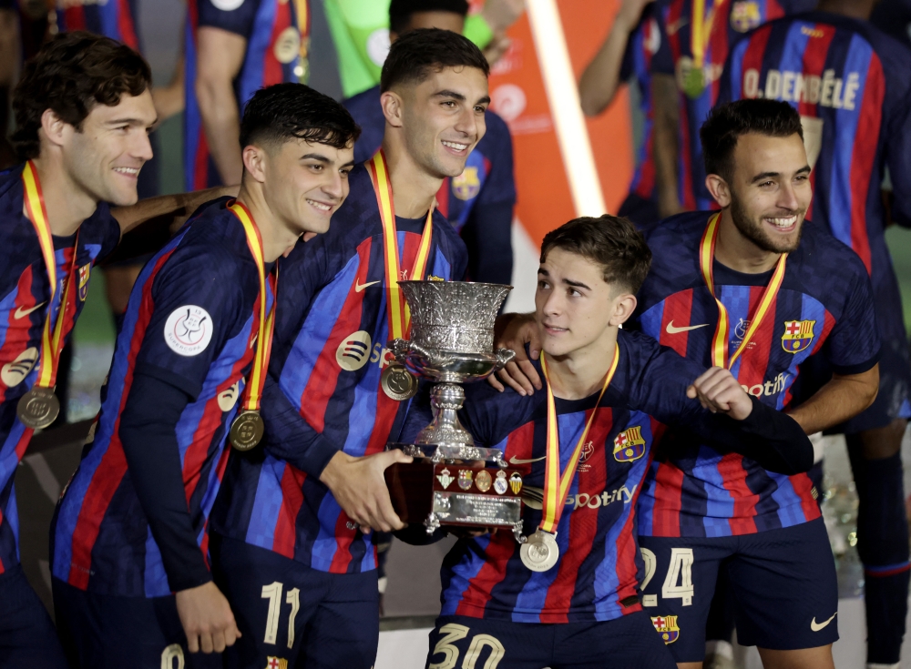 FC Barcelona's Marcos Alonso, Pedri, Ferran Torres, Gavi and Eric Garcia celebrate with the trophy after winning the Spanish Super Cup Reuters/Ahmed Yosri
