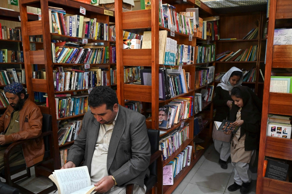In this photograph taken on December 14, 2022, people read books inside the Darra Adam Khel Library in Darra Adamkhel town, some 35 kilometres (20 miles) south of Peshawar. (Photo by Abdul Majeed / AFP)
