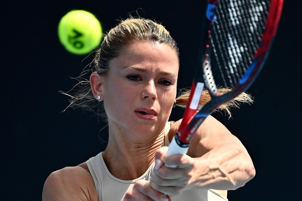 Italy's Camila Giorgi hits a return against Russia's Anastasia Pavlyuchenkova during their women's singles match on day two of the Australian Open tennis tournament in Melbourne on January 17, 2023. (Photo by MANAN VATSYAYANA / AFP) 