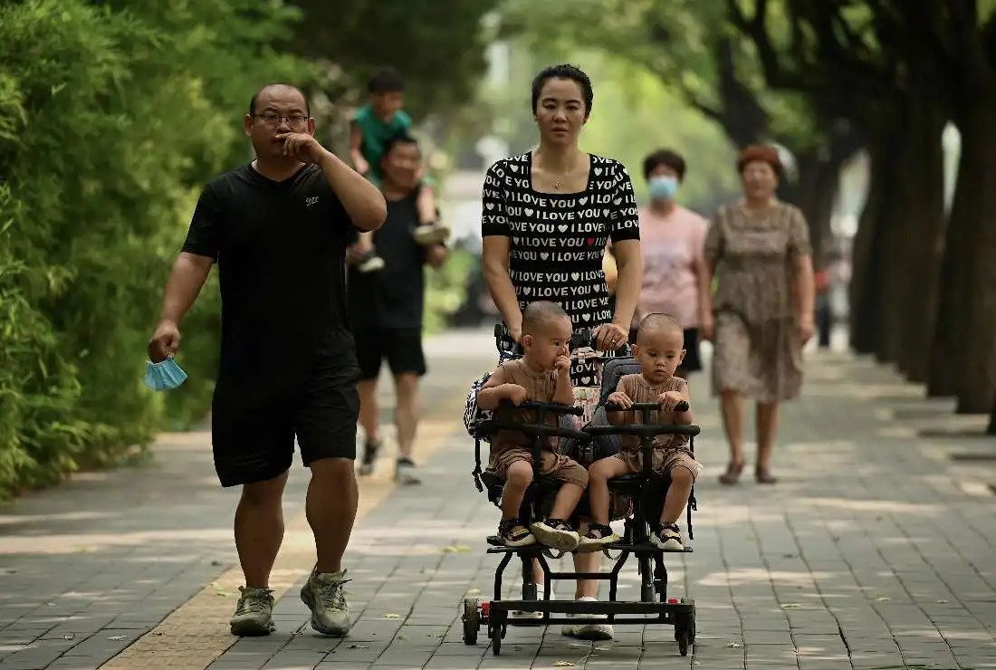 A woman pushes a trolley with twins along a street in Beijing on Aug. 2, 2022. (Photo: AFP)

