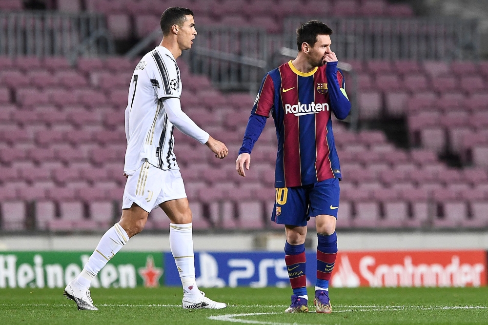  In this file photo taken on December 08, 2020 Juventus' Portuguese forward Cristiano Ronaldo walks past Barcelona's Argentinian forward Lionel Messi during the UEFA Champions League group G football match between Barcelona and Juventus at the Camp Nou stadium in Barcelona. (Photo by Josep LAGO / AFP)
 