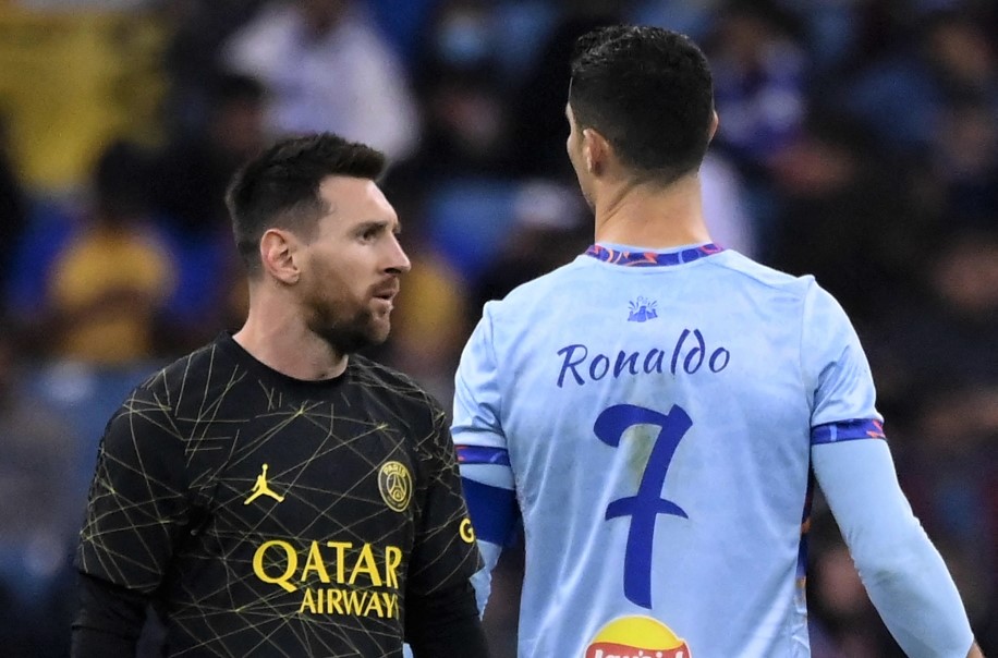 Paris Saint-Germain's Argentine forward Lionel Messi walks past Riyadh All-Star's Portuguese forward Cristiano Ronaldo during the Riyadh Season Cup football match between the Riyadh All-Stars and Paris Saint-Germain at the King Fahd Stadium in Riyadh on January 19, 2023. (Photo by FRANCK FIFE / AFP)