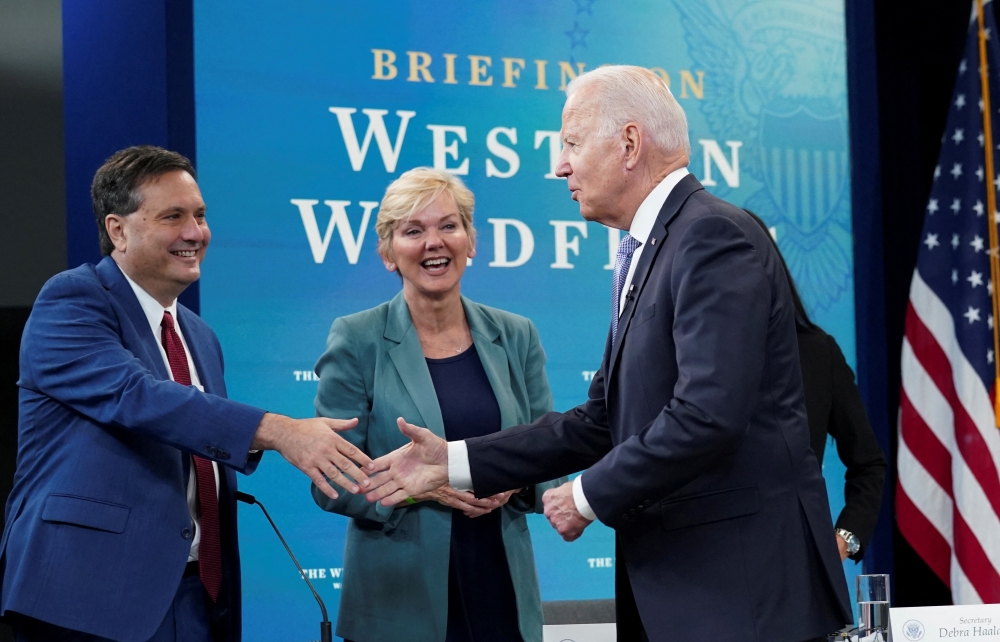 US President Joe Biden shakes hands White House Chief of Staff Ron Klain as Energy Secretary Jennifer Granholm looks on as he arrives for a meeting with cabinet officials, governors, and private sector partners to discuss preparedness of Western states to heat, drought and wildfires this season, at the White House in Washington, US on June 30, 2021. File Photo / Reuters