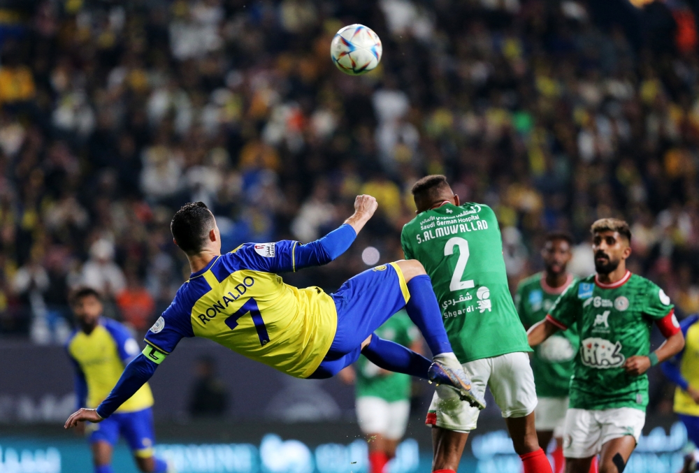 Al Nassr's Cristiano Ronaldo in action with Al Ettifaq's Saeed Al-Mowalad during the Saudi Pro League match between Al-Nassr and Al-Ettifaq at the King Fahd Stadium in the Saudi capital Riyadh on January 22, 2023. (REUTERS/Ahmed Yosri)