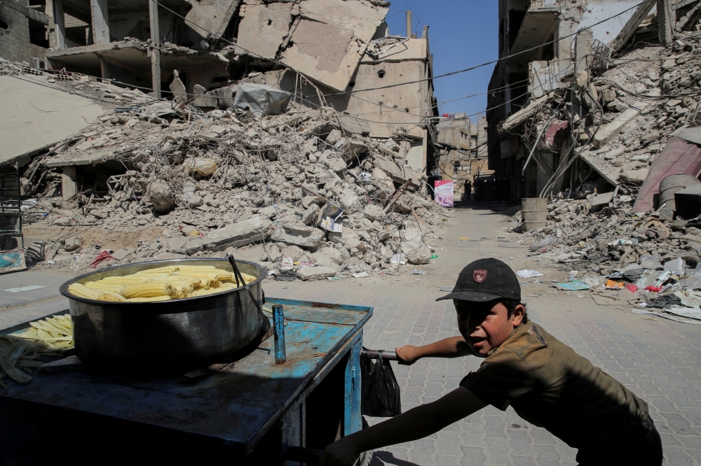File Photo: A child pushes a cart selling cooked sweetcorn in Douma, outside Damascus, Syria, September 17, 2018. (REUTERS/Marko Djurica)