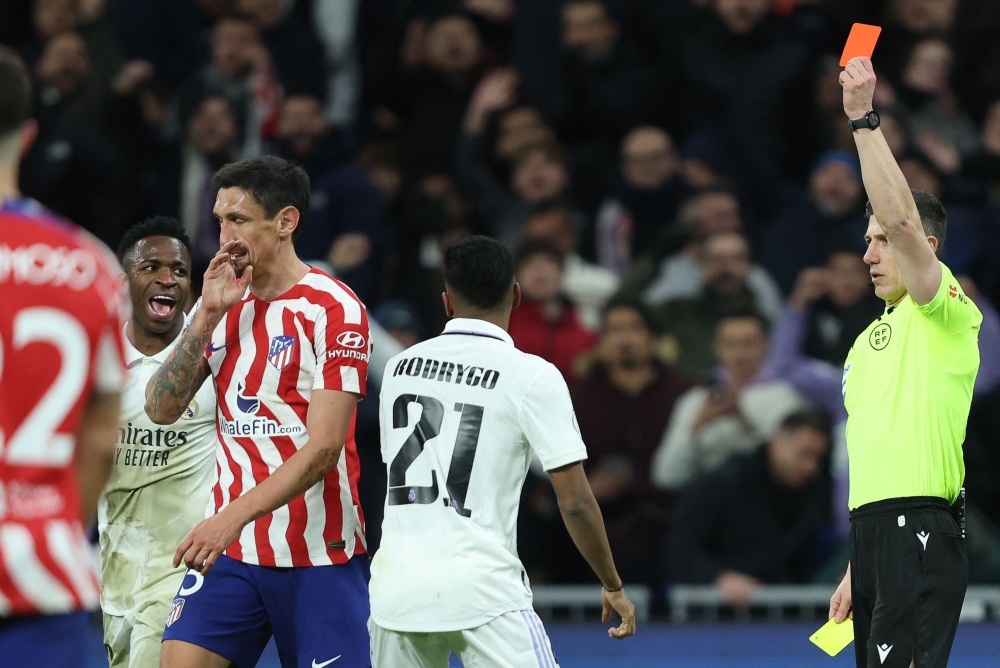Spanish referee Cesar Soto Grado (right) gives a red card to Atletico Madrid's Montenegrin defender Stefan Savic (second left) during the Copa del Rey (King's Cup), quarter final football match between Real Madrid CF and Club Atletico de Madrid at the Santiago Bernabeu stadium in Madrid on January 26, 2023. (Photo by Thomas COEX / AFP)