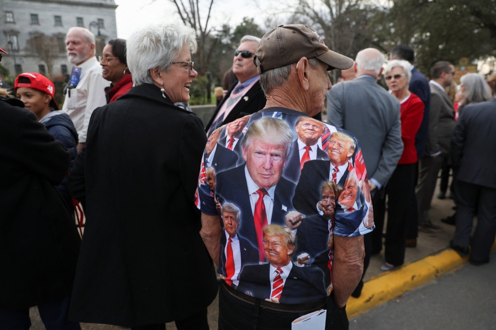 A man wears a T-shirt with images of former US President Donald Trump on it, on the day of Donald Trump's campaign stop to unveil his leadership team, at the South Carolina State House in Columbia, South Carolina, US, January 28, 2023. REUTERS/Shannon Stapleton