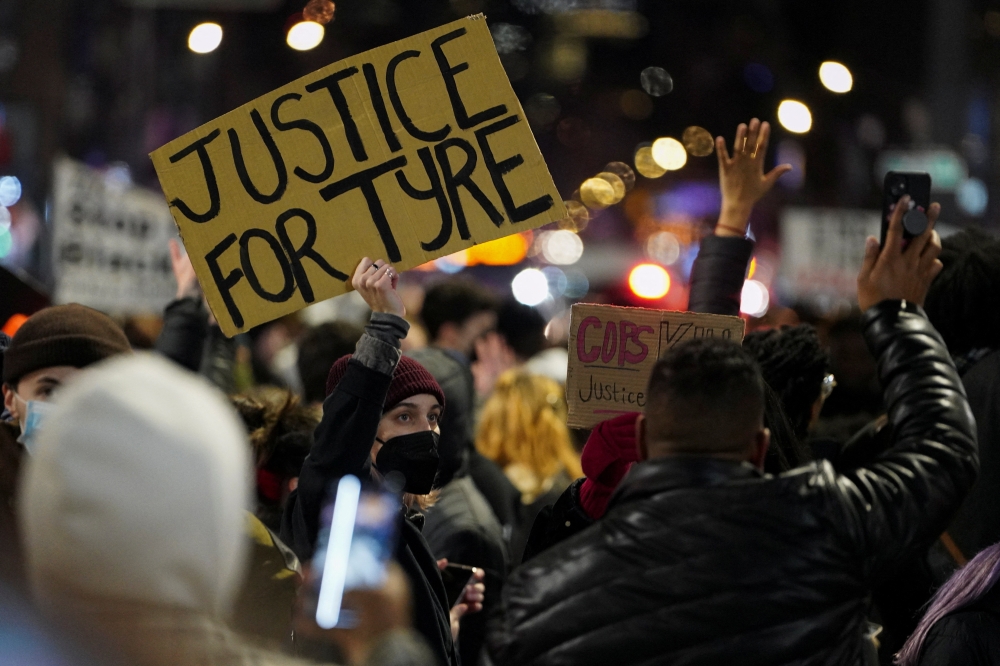 People hold signs during a protest following the release of videos showing Memphis police officers beating Tyre Nichols, who died while hospitalized three days later, in New York, U.S., January 28, 2023. REUTERS/David Dee Delgado