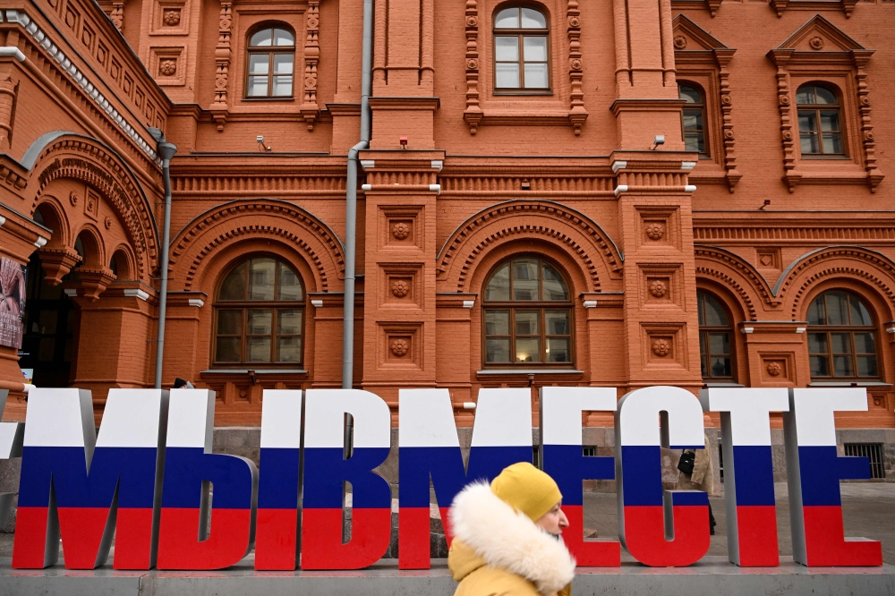 A woman walks past huge letters reading 