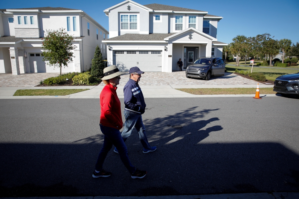 A couple walks in front of the house where former Brazilian President Jair Bolsonaro is staying, in Kissimmee, Florida, US, on January 11, 2023. REUTERS/Marco Bello/File Photo