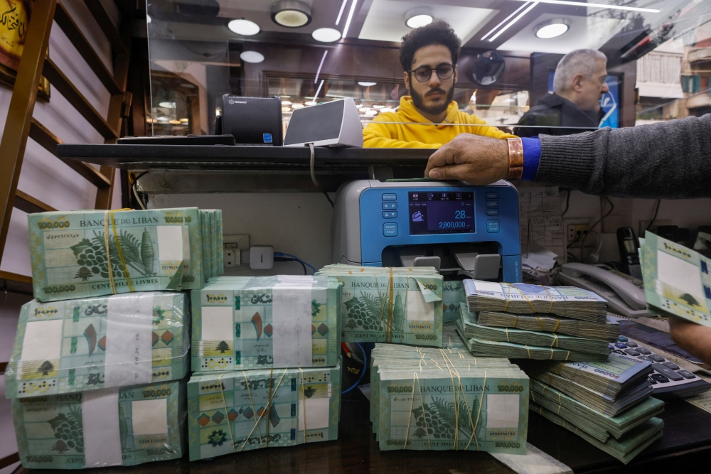 A man counts Lebanese pound banknotes at an exchange shop in Beirut, Lebanon, January 11, 2023. (REUTERS/Mohamed Azakir)