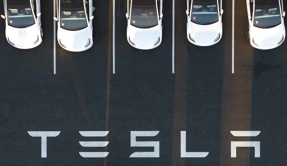 In this file photo taken on February 10, 2022, an aerial view shows cars parked at the Tesla Fremont Factory in Fremont, California. (Photo by JOSH EDELSON / AFP)