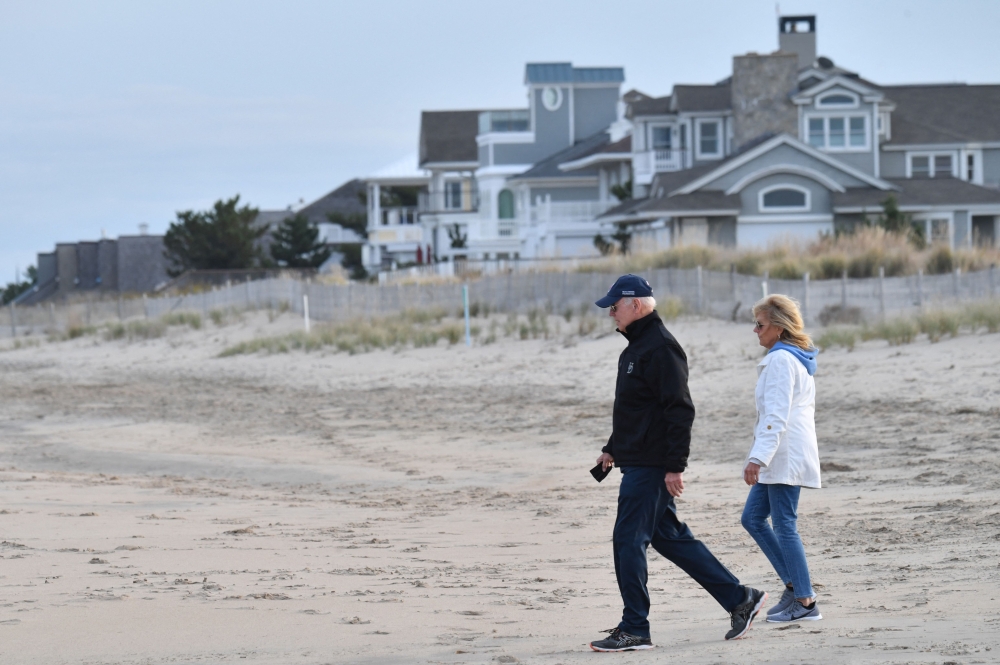 In this file photo taken on November 07, 2021, US President Joe Biden and First Lady Jill Biden walk on Rehoboth Beach, Delaware.  (Photo by Nicholas Kamm / AFP)