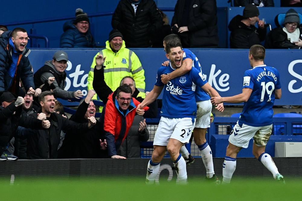 Everton's  defender James Tarkowski (centre) celebrates with teammates after scoring a goal during the English Premier League match between Everton and Arsenal at Goodison Park in Liverpool, north-west England, on February 4, 2023. (Photo by Paul ELLIS / AFP) 