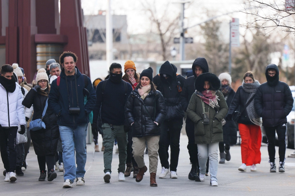 People bundle up as they shield themselves from cold winds as the area is seeing record-breaking low temperatures on February 03, 2023 in New York City. The Northeast US has seen a dramatic temperature drop as an Arctic front of cold air hits it. Michael M. Santiago/Getty Images/AFP 