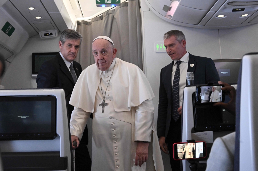 Pope Francis arrives to address the media while aboard the plane from Juba to Rome on February 5, 2023 returning from he Pope's visit to Democratic Republic of Congo and South Sudan. (Photo by Tiziana FABI / POOL / AFP)