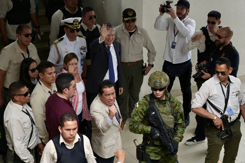 Ecuadorean President Guillermo Lasso gestures after voting during the local election at the Ileana Espinel Cedeٌo school in Guayaquil, Ecuador on February 5, 2023. (Photo by Marcos Pin / AFP)