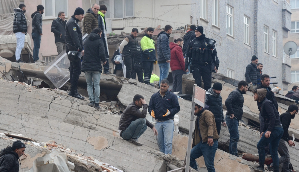 People search for survivors through the rubble in Diyarbakir, on February 6, 2023, after a 7.8-magnitude earthquake struck the country's south-east. (Photo by Ilyas Akengin / AFP)
 
