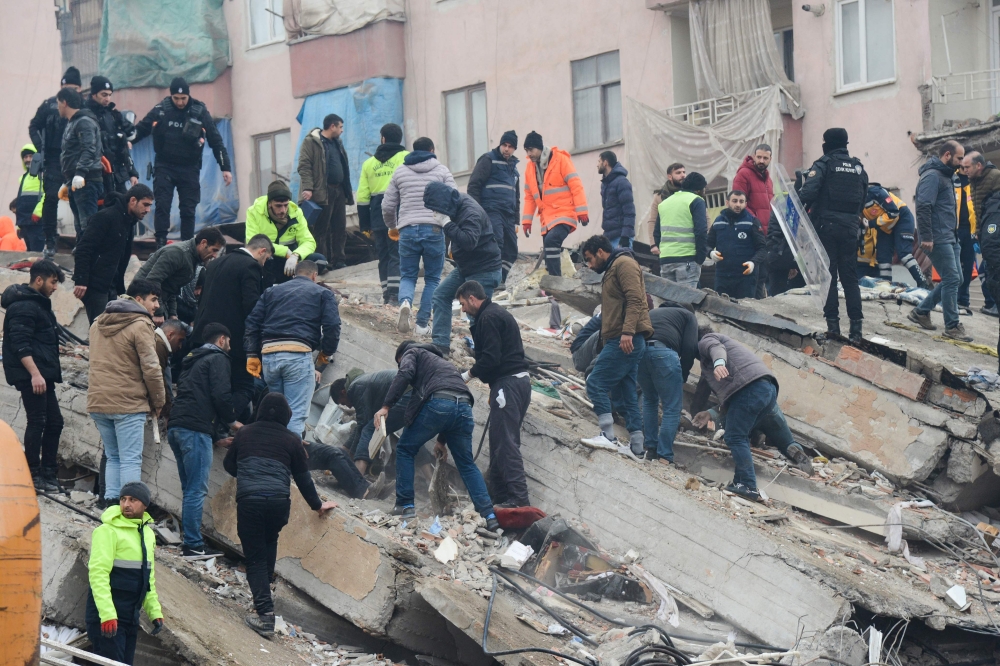 People search for survivors through the rubble in Diyarbakir, on February 6, 2023, after a 7.8-magnitude earthquake struck the country's south-east. Photo by ILYAS AKENGIN / AFP