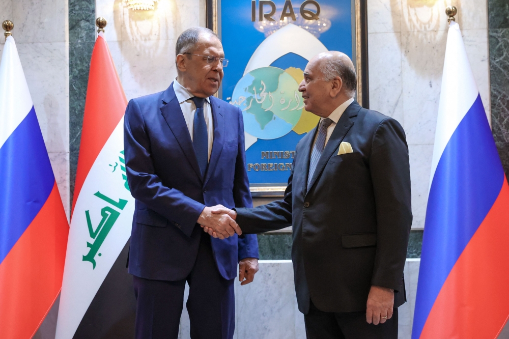 Russian Foreign Minister Sergei Lavrov (left) and his Iraq's counterpart Fuad Hussein pose for photos as they arrive for a meeting at the foreign ministry in Baghdad on February 6, 2023. (Handout / RUSSIAN FOREIGN MINISTRY / AFP)
