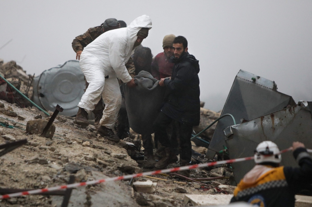 Rescue teams carry a casualty pulled out of the rubble following an earthquake in the town of Jan-daris, in the countryside of Syria's northwestern city of Afrin in the rebel-held part of Aleppo province, on February 6, 2023. (Photo by Bakr ALKASEM / AFP)
